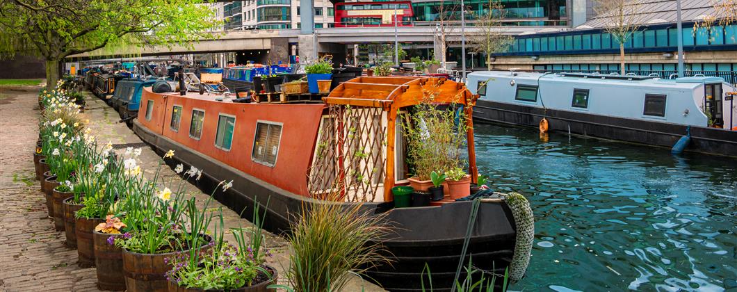 narrowboat moored on the Grand Union canal with flowers outside